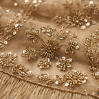 A luxurious ochre gold net saree adorned with dense floral embroidery